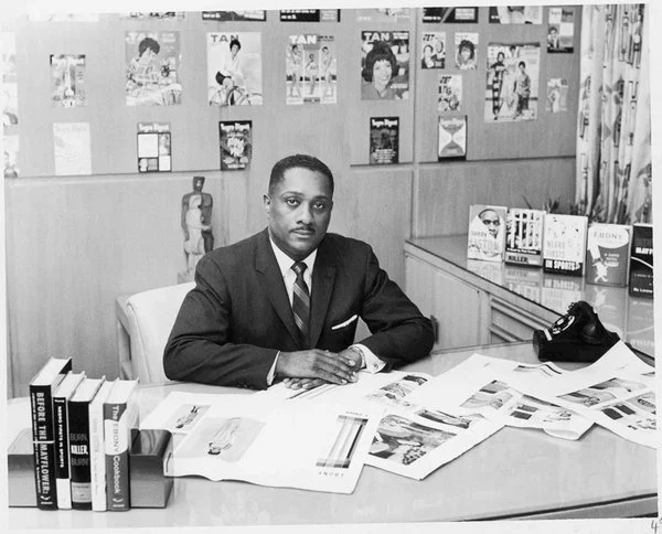 Black and white photo of John H. Johnson sitting at his desk