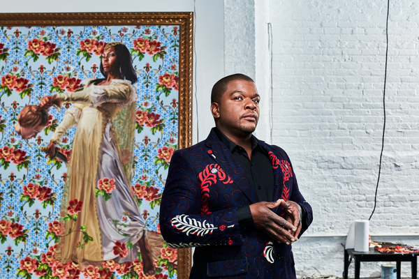 Kehinde Wiley posing in front of his artwork